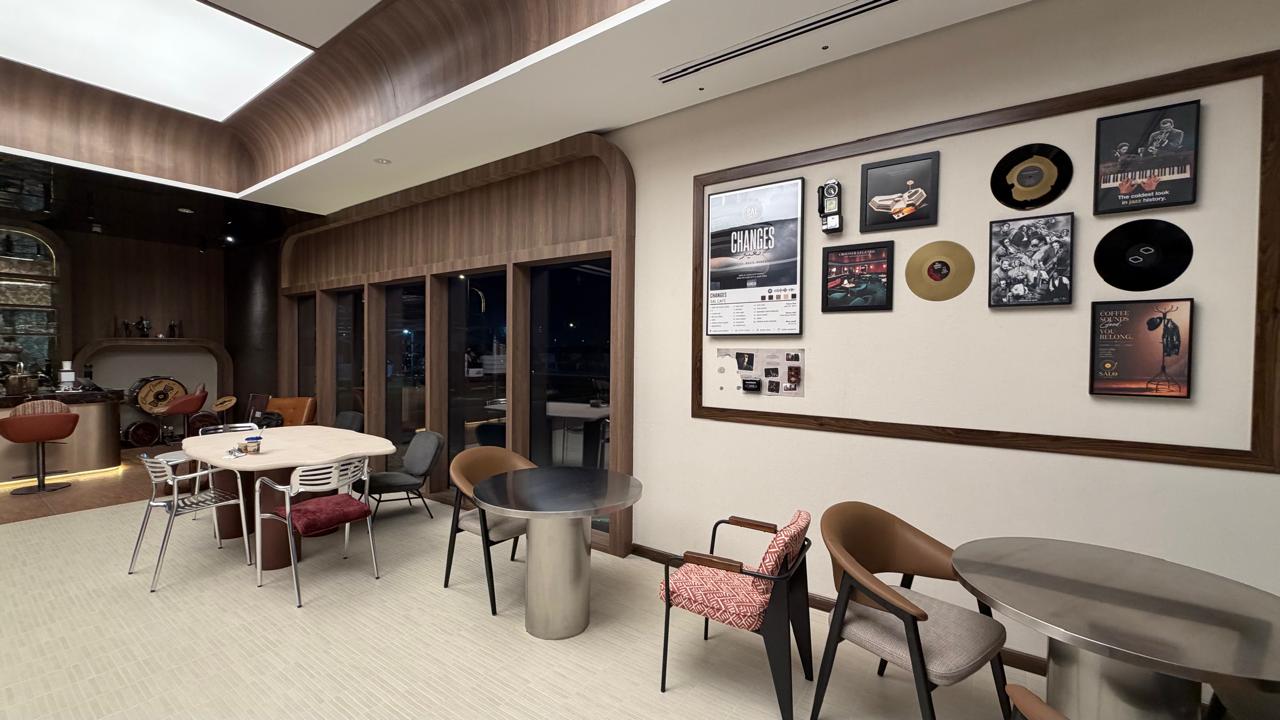 Timber-framed gallery wall of records and posters beside the café windows