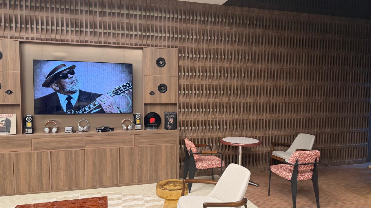 Timber media wall with built-in speakers beside a 3D slatted feature wall