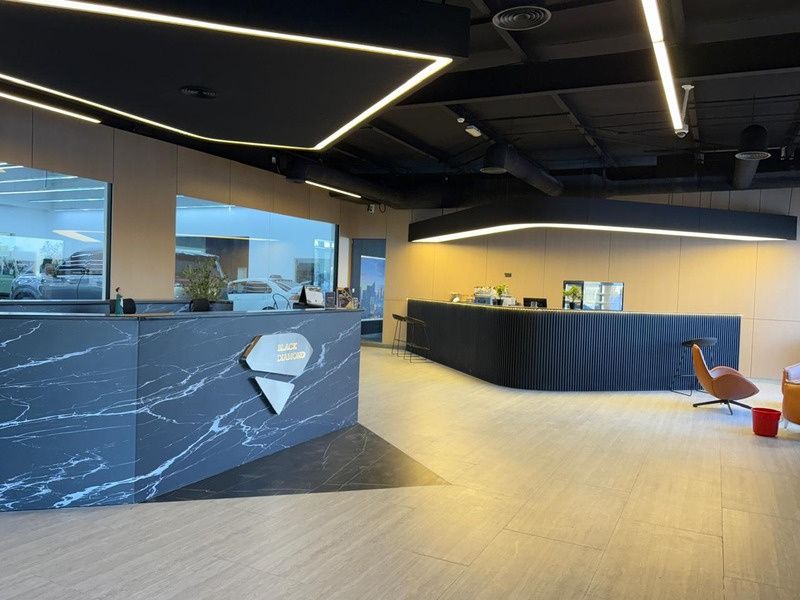 Showroom reception with marble-clad counter and linear ceiling lights